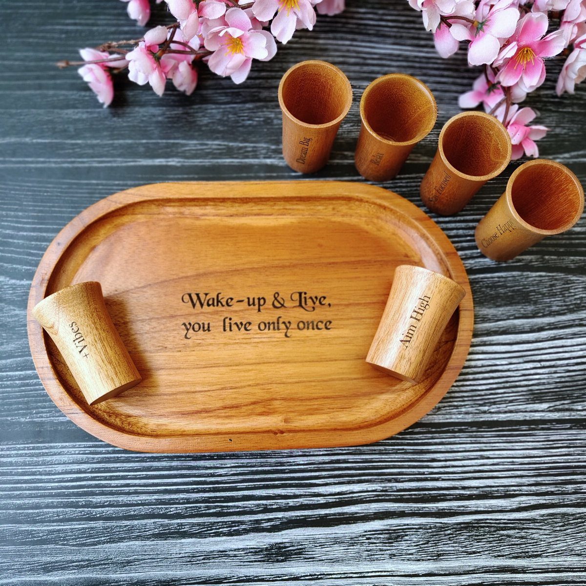Wooden bar tray with engraved quote and matching wooden shot glasses and blossoms