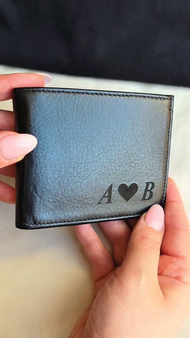 Black leather wallet with engraved initials A and B separated by a heart.