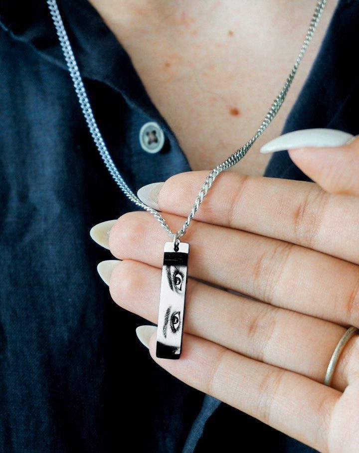 Silver rectangular pendant necklace featuring a black and white photo of eyes.