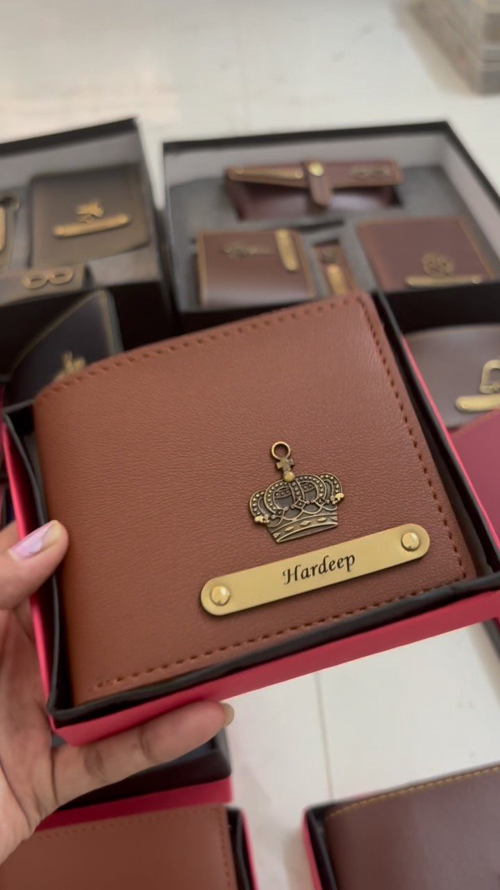 Brown leather wallet with a gold crown and engraved name in a gift box