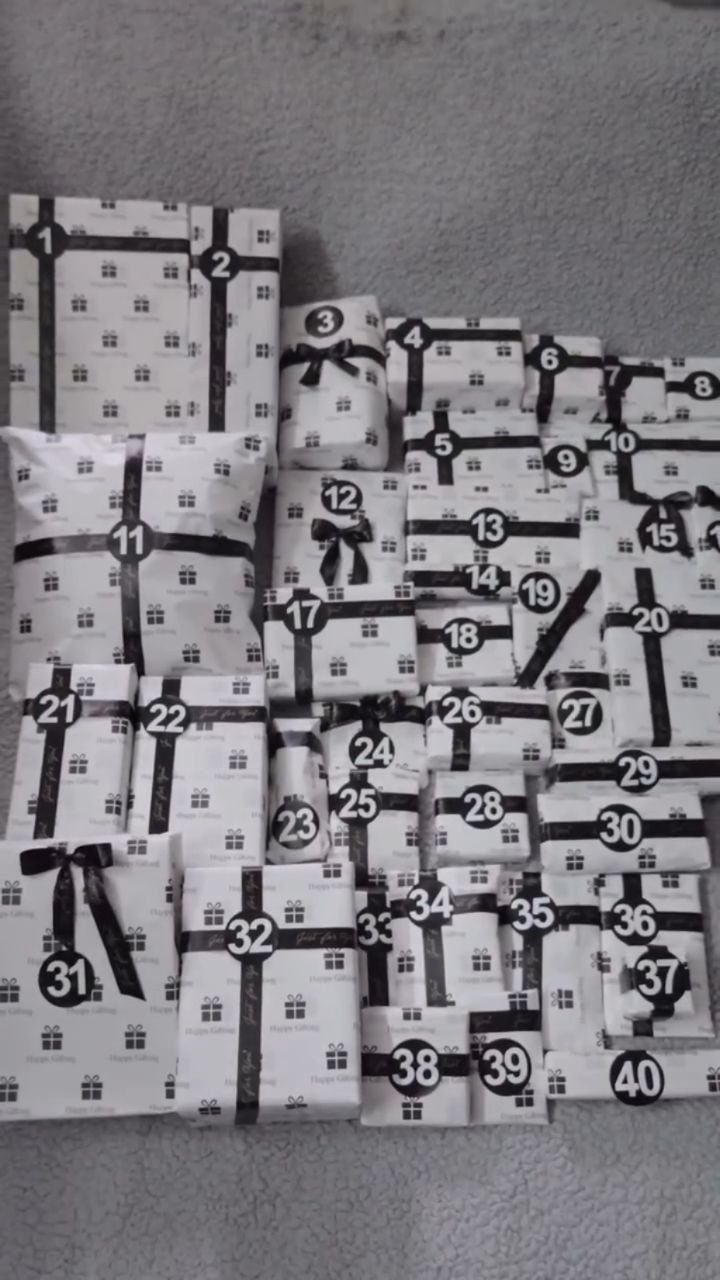 Forty numbered wrapped gifts in white and black for a 40th birthday celebration.
