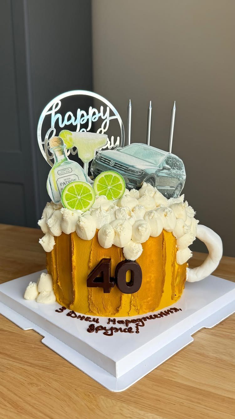 Beer mug shaped cake with number 40, miniature car, and cocktail decorations.