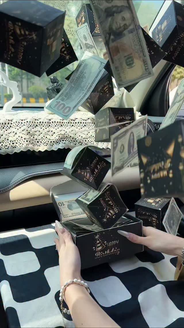 Black explosion box popping open with small boxes and dollar bills flying out.