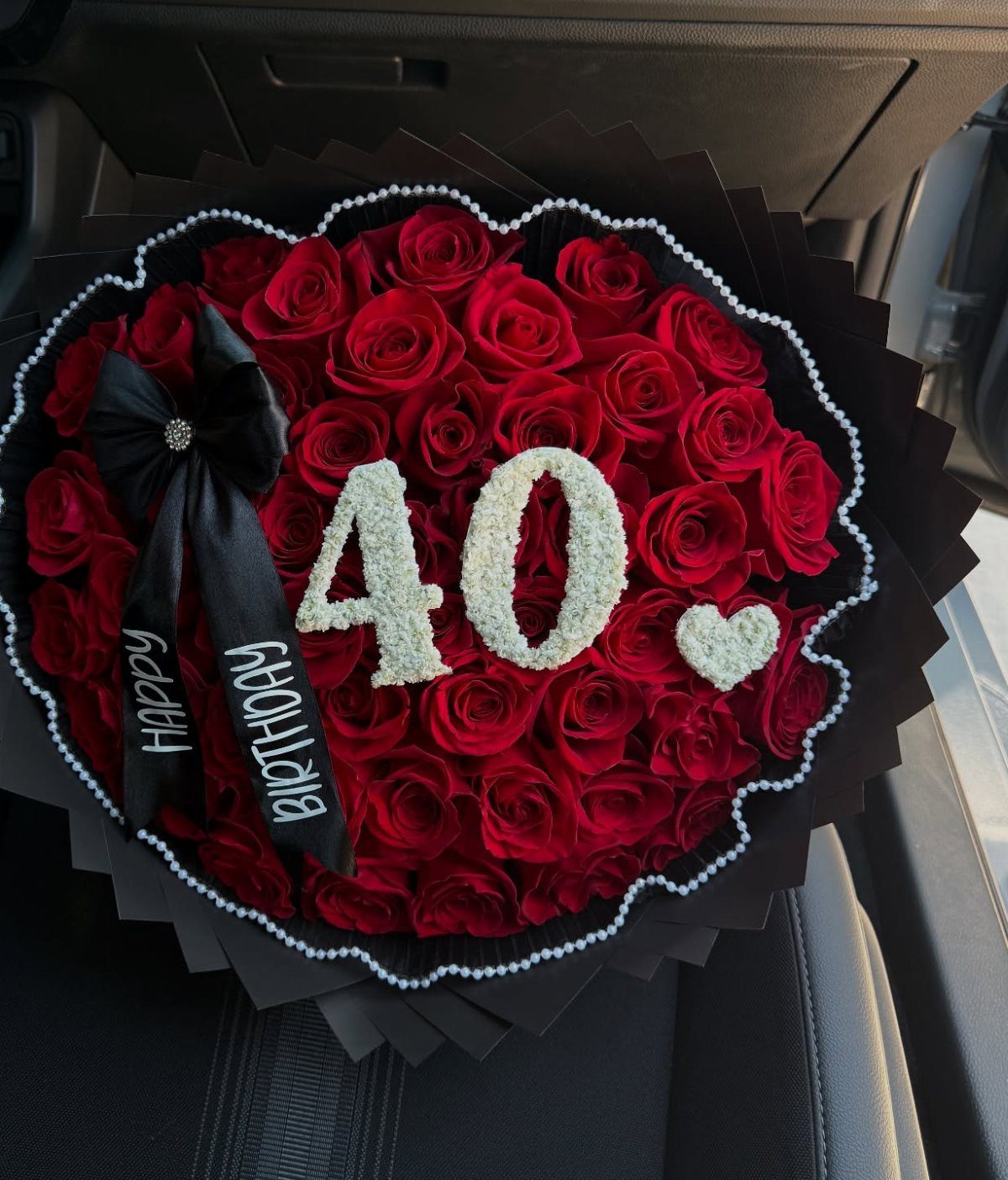 Red rose bouquet with white flowers forming the number 40 and a heart.