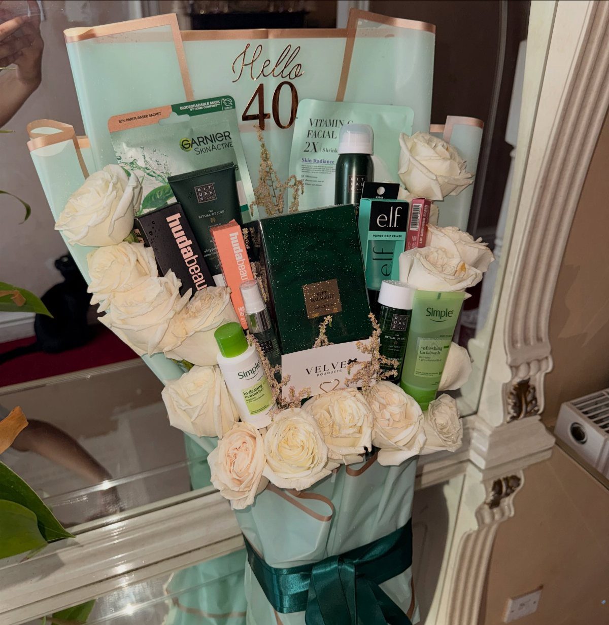 Gift bouquet with white roses and skincare products for a 40th birthday celebration.