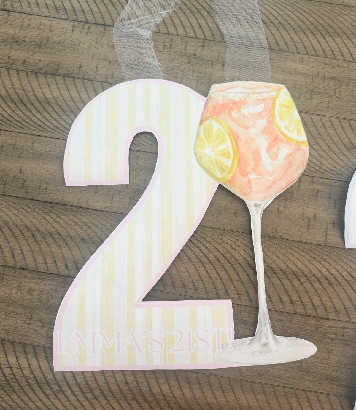Neck sign with a striped number 2 and cocktail glass on wooden background