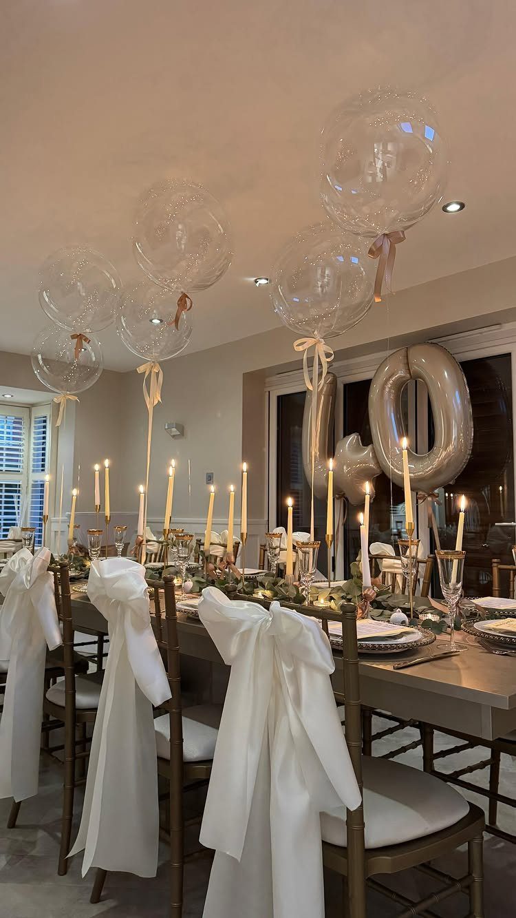 Elegant dining table set for a 40th birthday with candles and clear balloons.