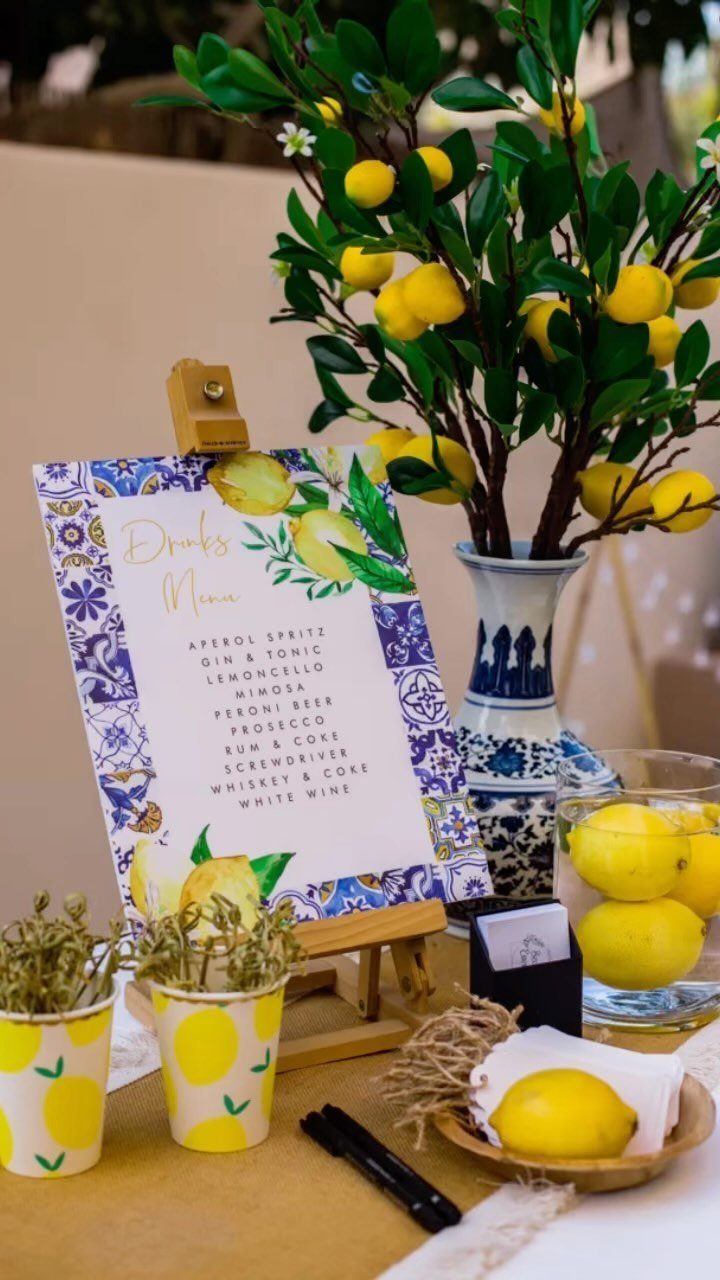 Drinks menu and lemon-themed decorations on a table for an outdoor garden party.