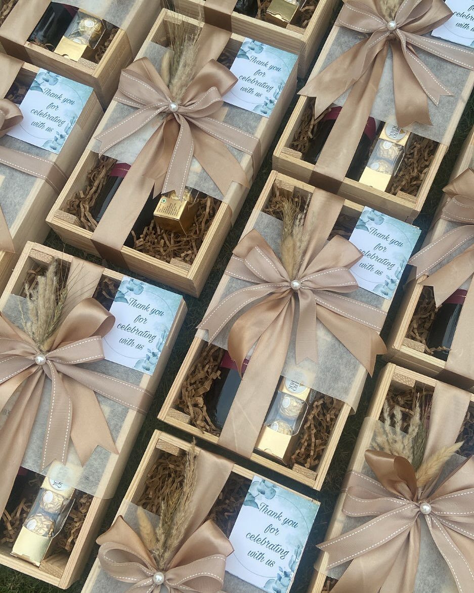 Wooden gift boxes with champagne bows and thank you cards for party guests.