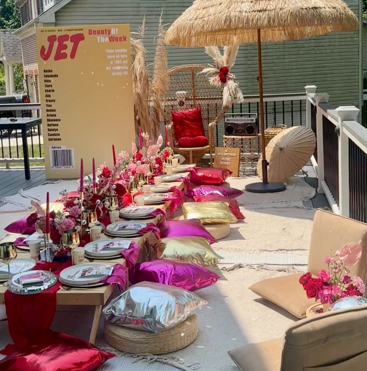 Luxury outdoor picnic setup with low table, metallic cushions, and floral decorations.