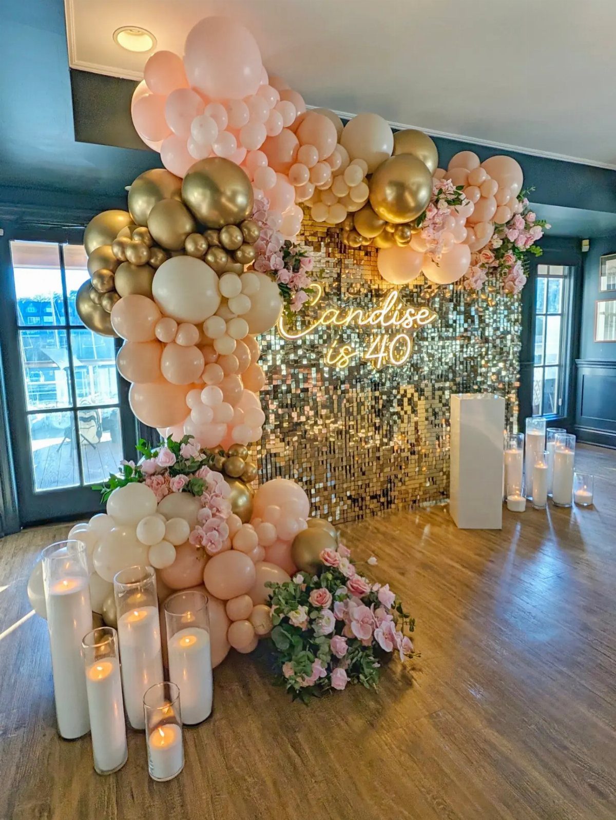 Gold sequin backdrop with neon 40th birthday sign and peach balloon arch.
