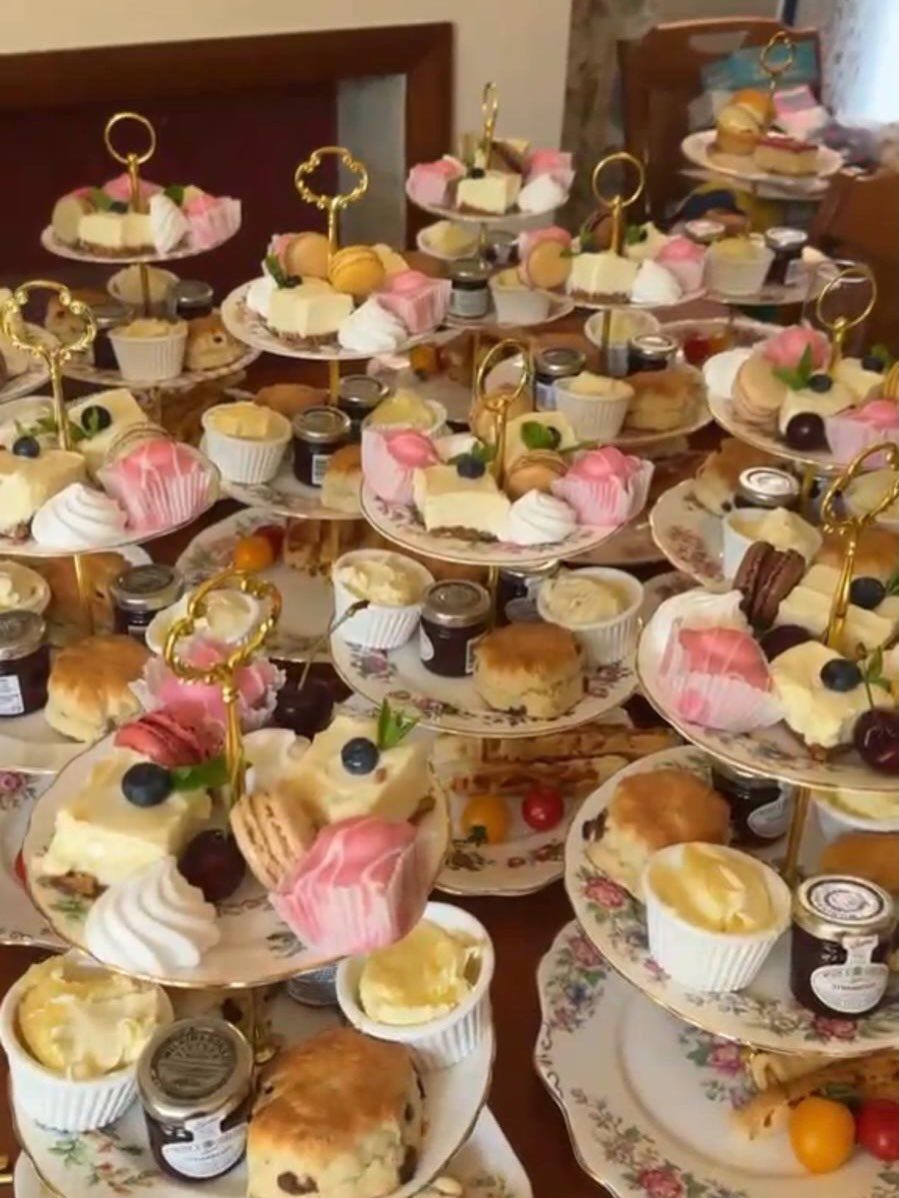 Tiered cake stands filled with assorted desserts and scones for a party celebration.