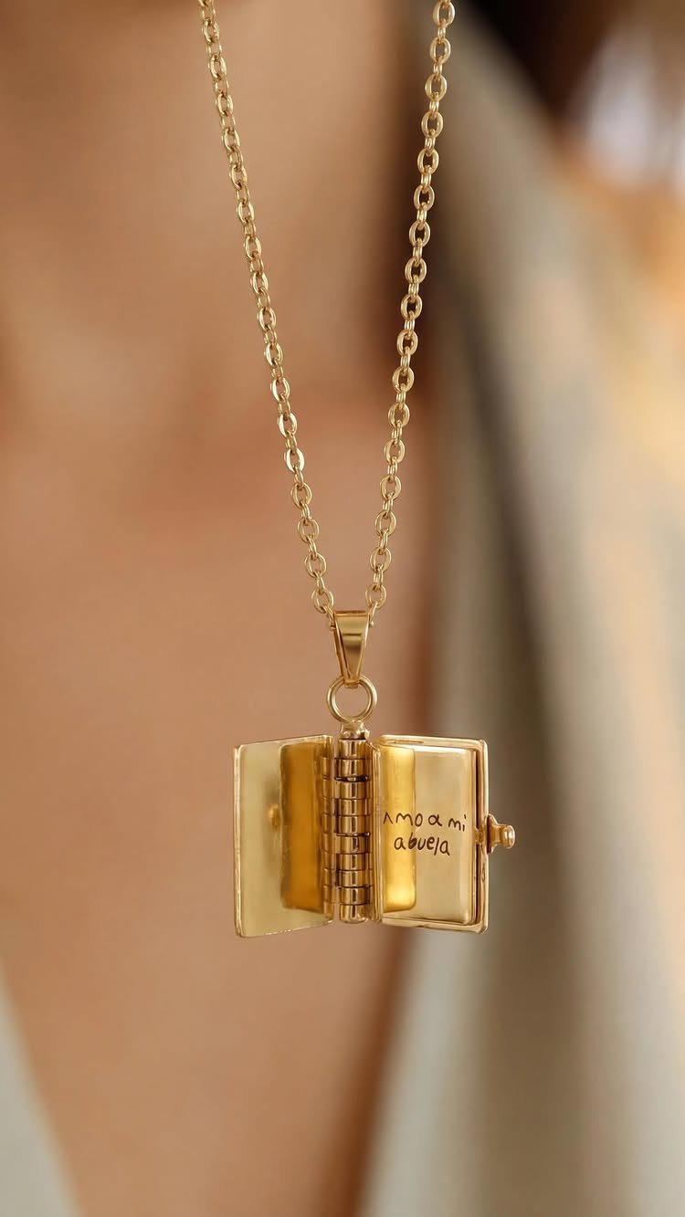 Gold book-shaped pendant necklace with personalized engraving worn around a person's neck.