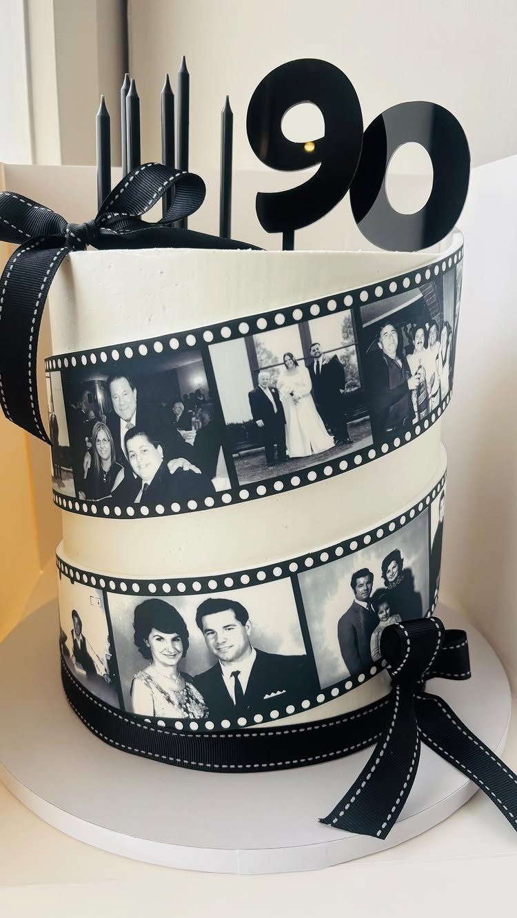 Two-tier white birthday cake with vintage photo film strips and a 90 topper.