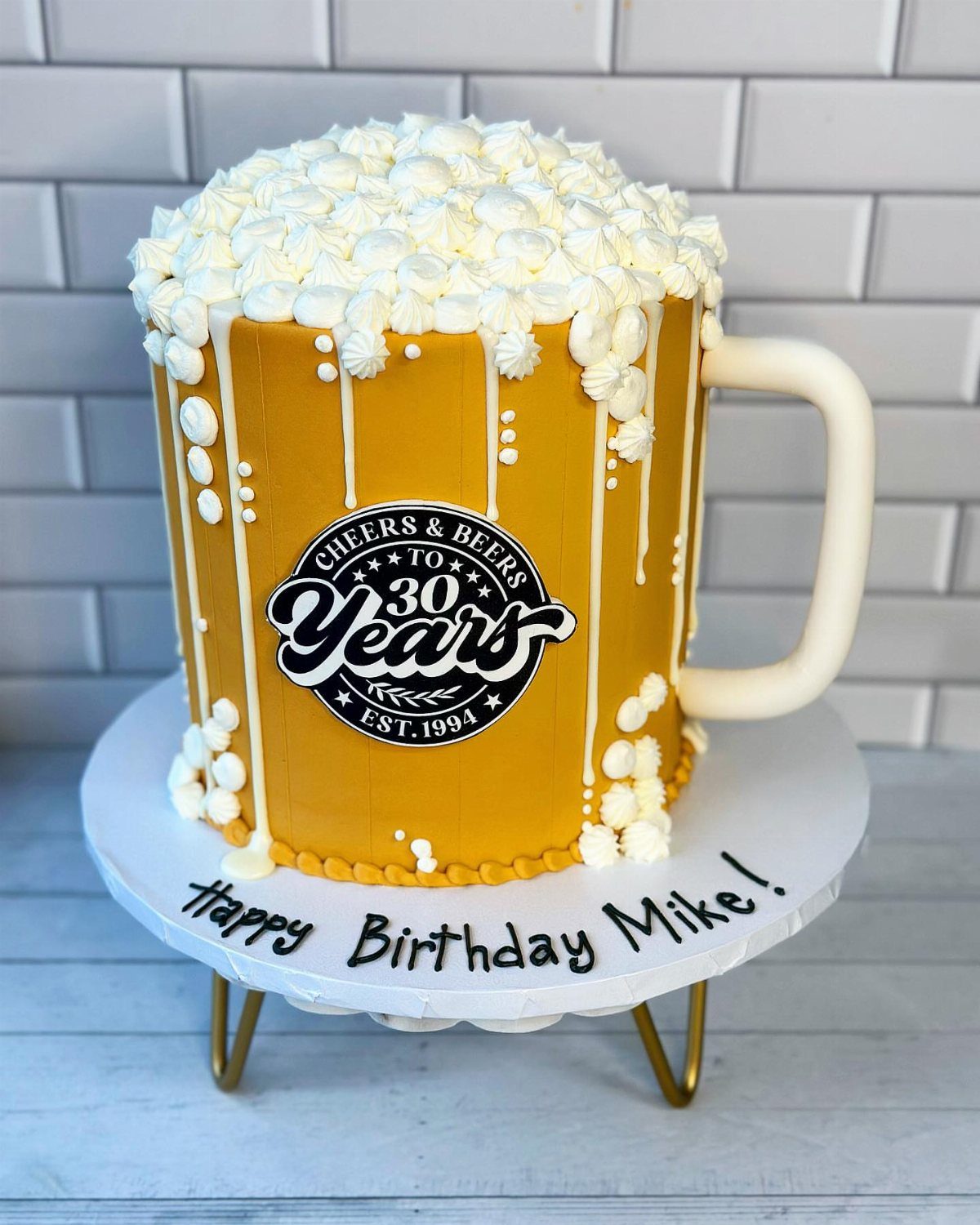 Beer mug shaped birthday cake with white foam frosting and 30th birthday logo.