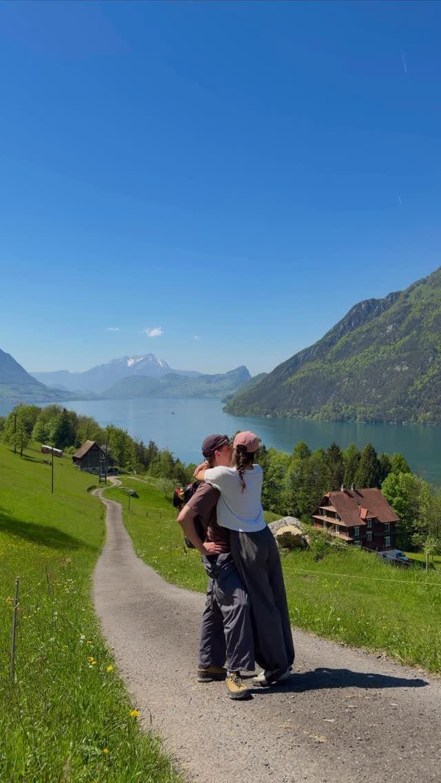 Couple kissing on a path overlooking a scenic lake and mountains in Switzerland