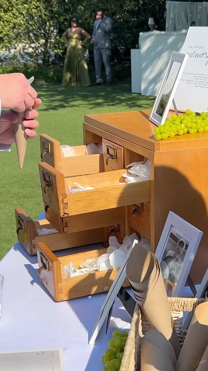 Wooden chest of drawers used as a memorial guest book with paper slips.
