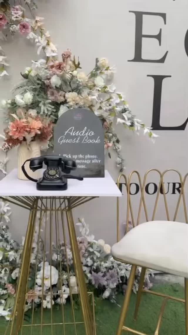 Vintage black rotary telephone audio guest book setup with floral decorations and gold accents