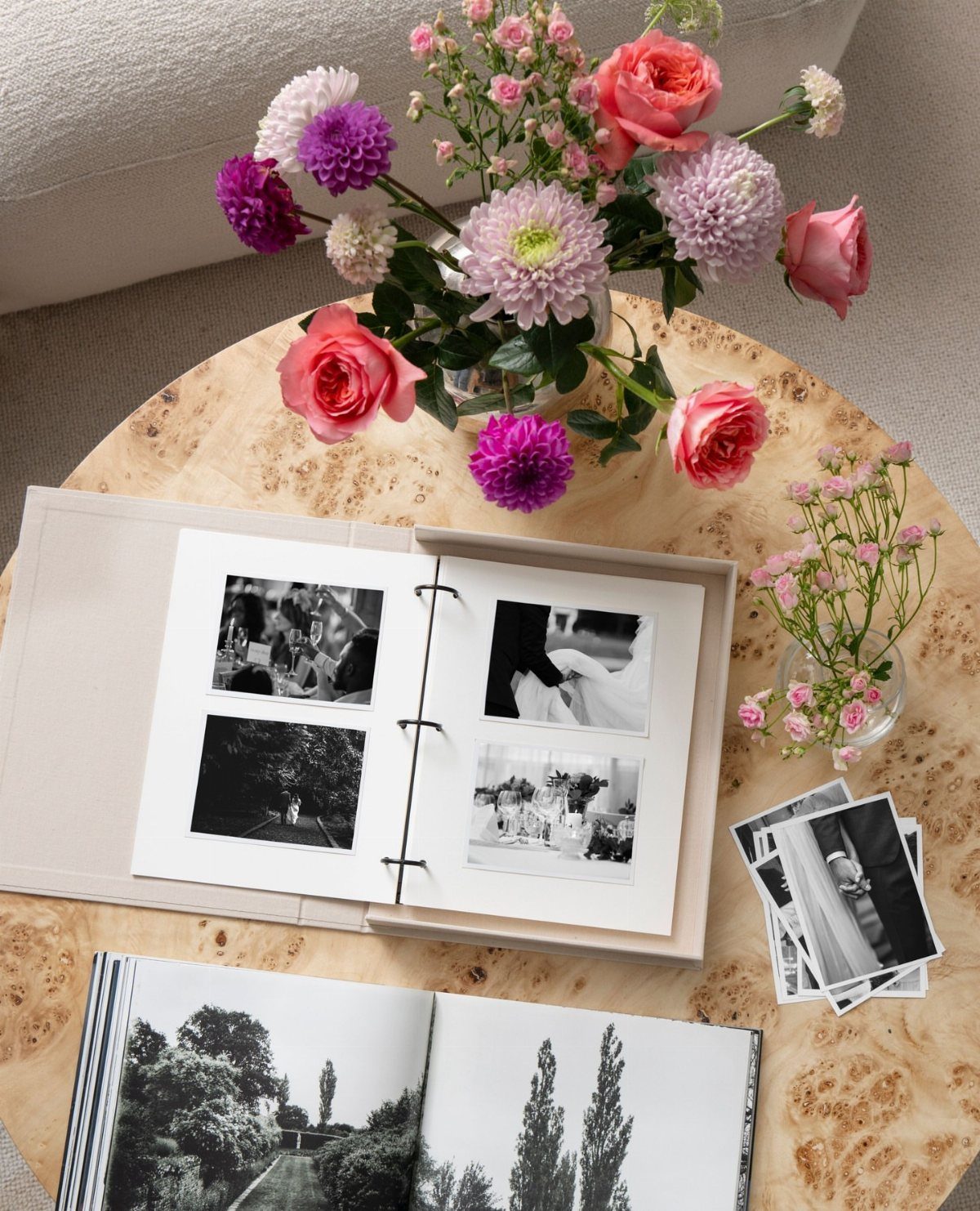 Memory table with open photo albums, black and white photos, and colorful flowers.