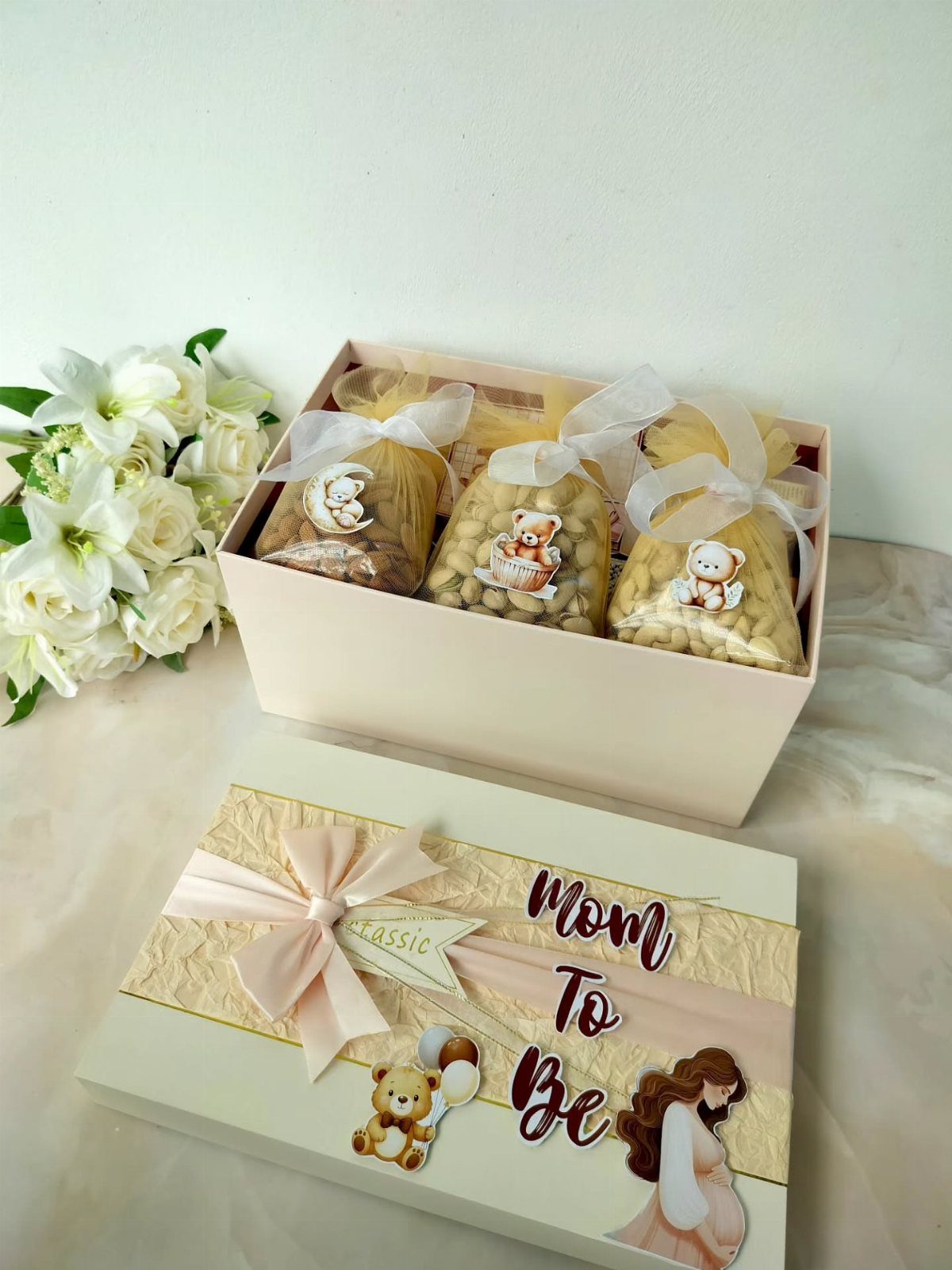 Pink gift box for a mom to be with treats and decorative lid