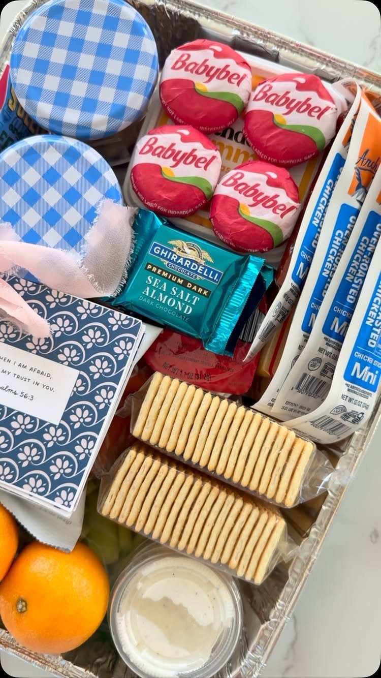 Gift tray filled with snacks, cheese, chocolate, and fruit for a mom to be.