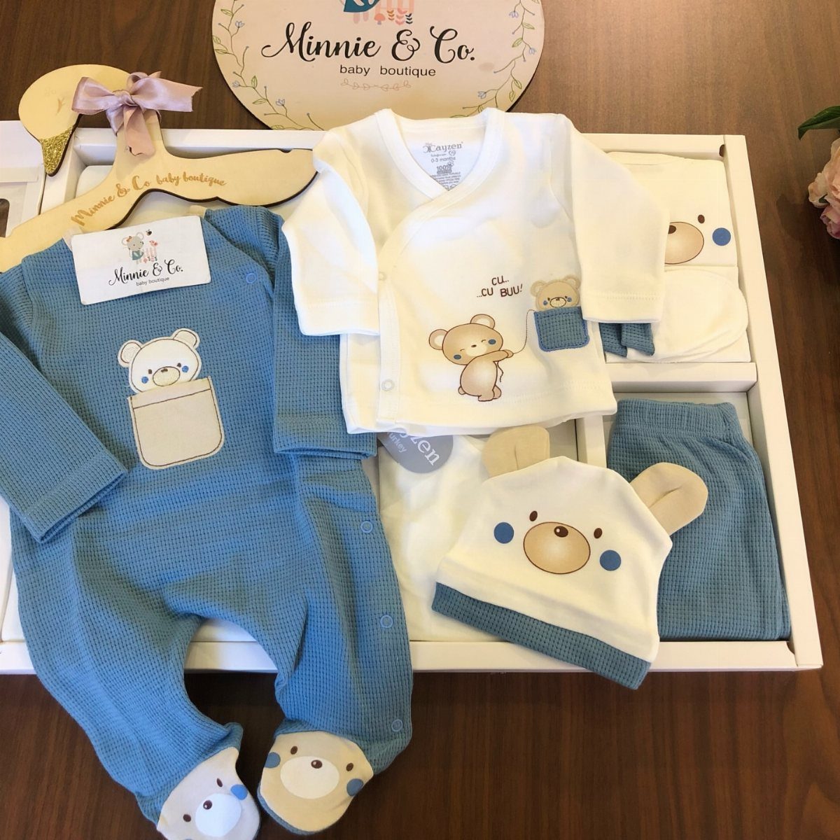 Newborn baby clothing set with blue and white bear themed outfits in a box