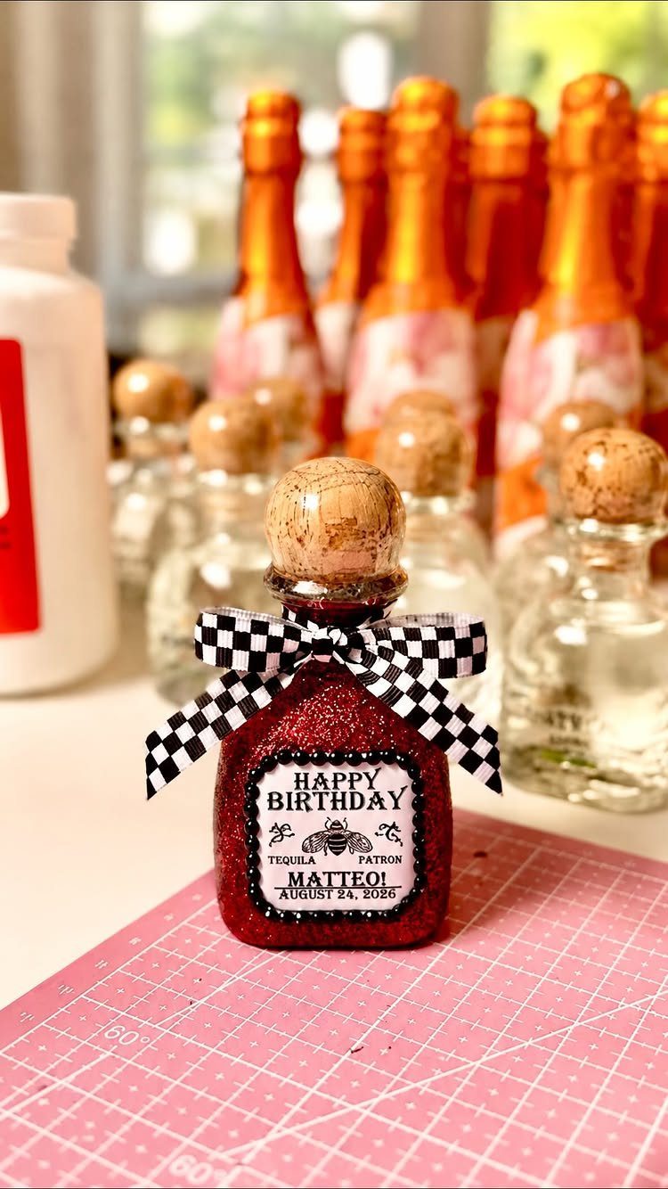 Miniature liquor bottles with checkered bows and birthday labels as party favors.