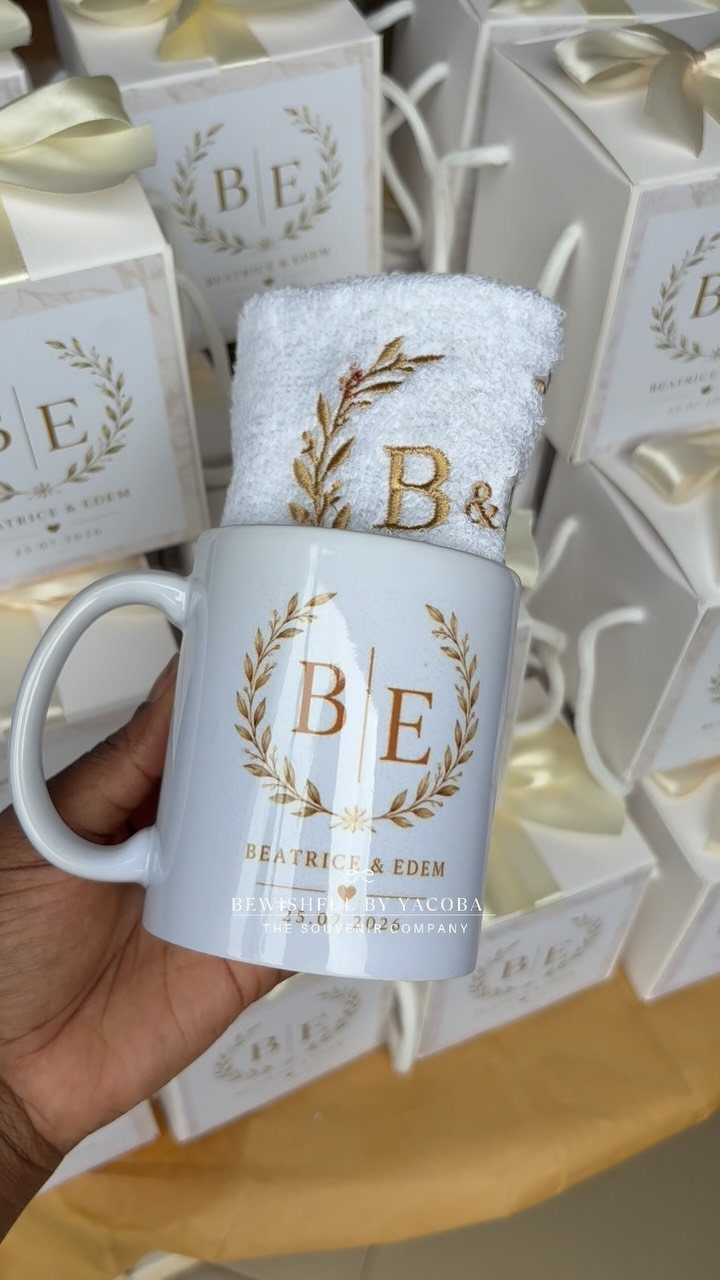 White ceramic mug with gold initials and a matching towel as a gift.