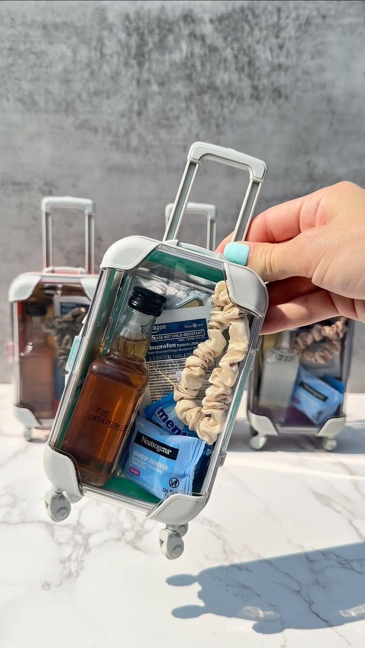 Small suitcase-shaped party favor containers filled with miniature liquor and accessories.
