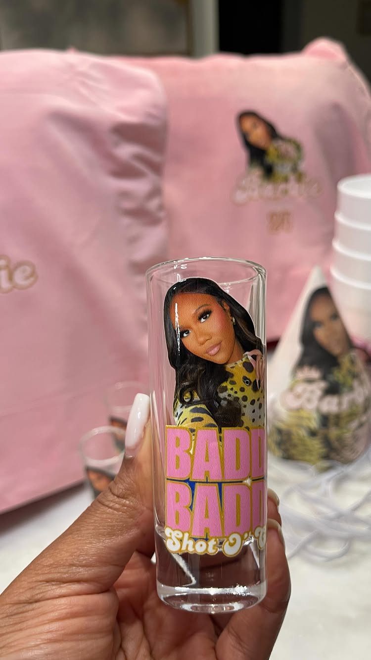 Custom shot glass with a woman's photo and pink text held in hand.