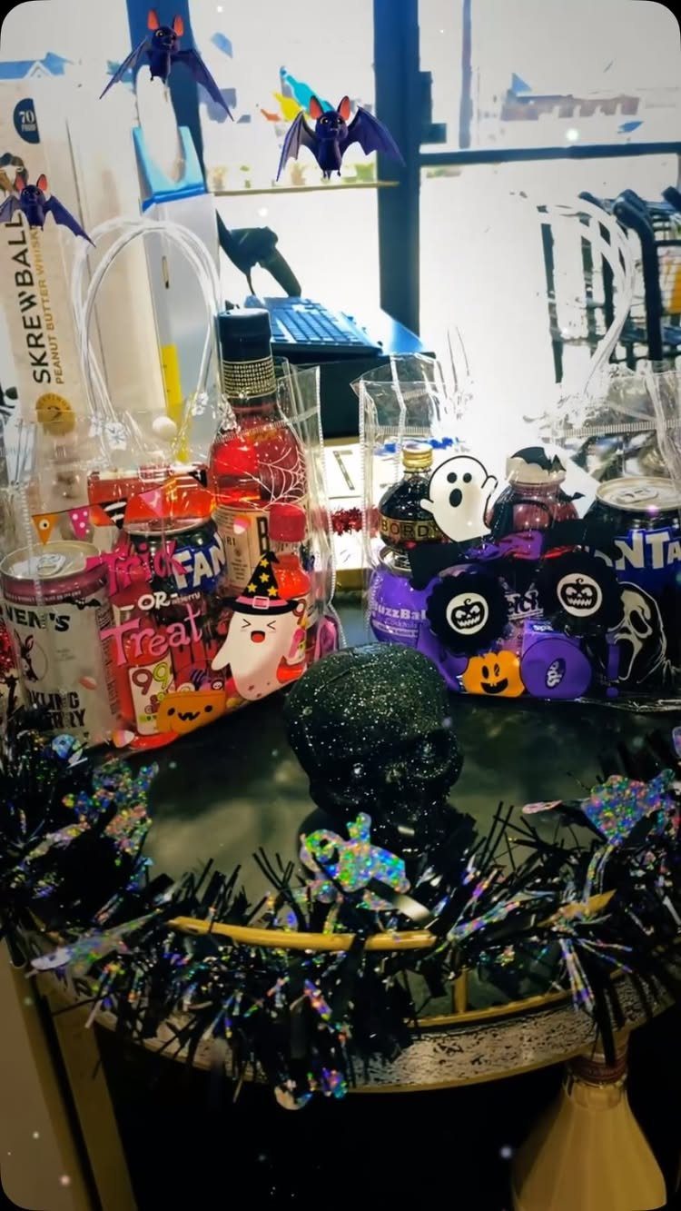 Halloween party favor baskets with mini liquor bottles and spooky decorations on a table