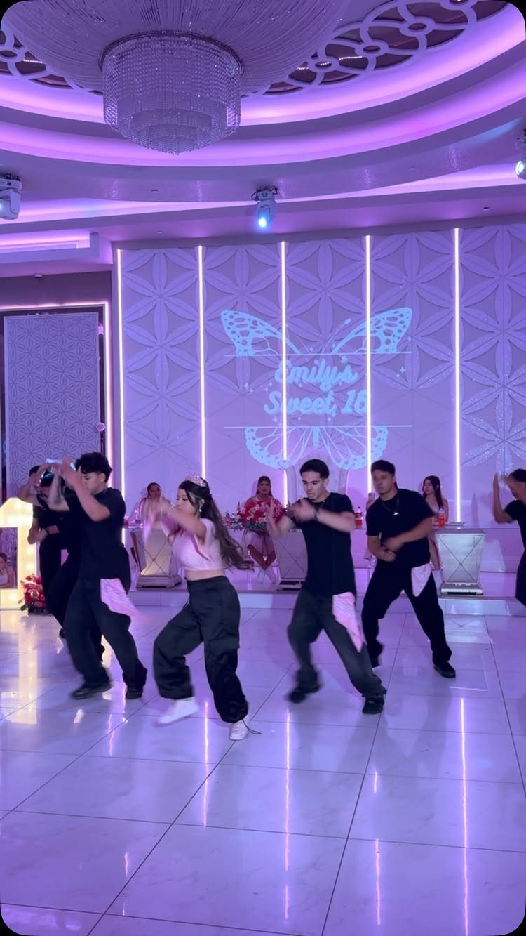 Teenagers dancing in a purple-lit ballroom at a Sweet 16 party celebration.