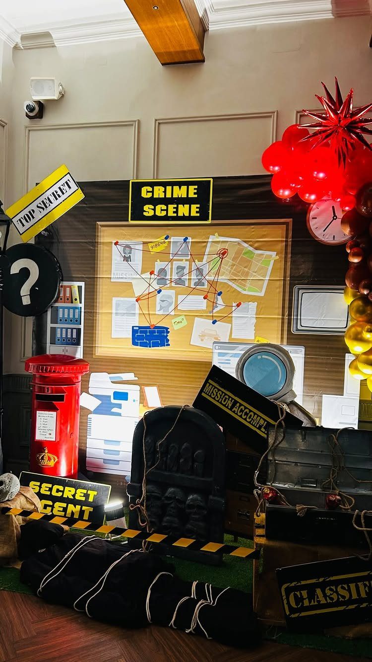 Detective crime scene setup with a clue board, red post box, and secret agent signs.