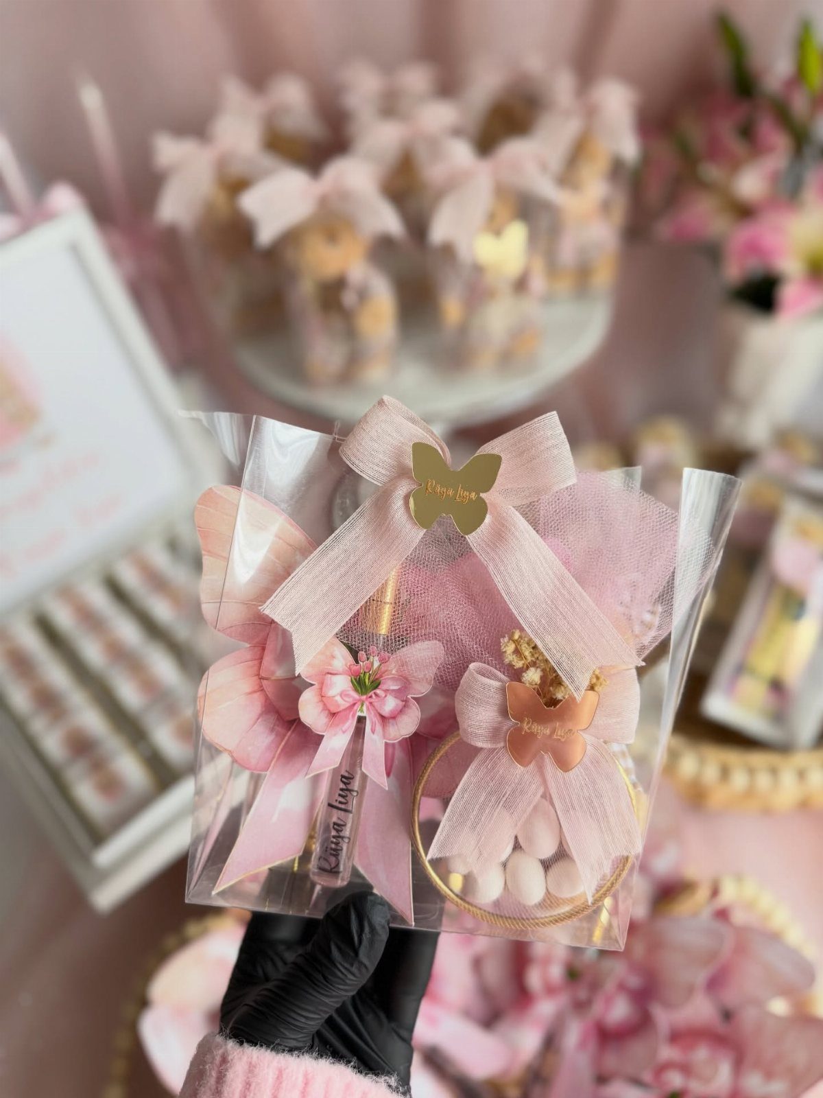 Pink themed party favor bag with a pen, bow, and pink candies.