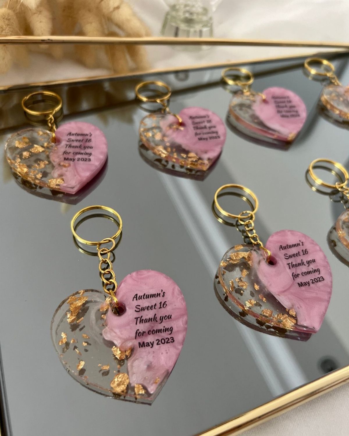 Heart-shaped resin keychains with gold foil and pink accents for a sweet 16.