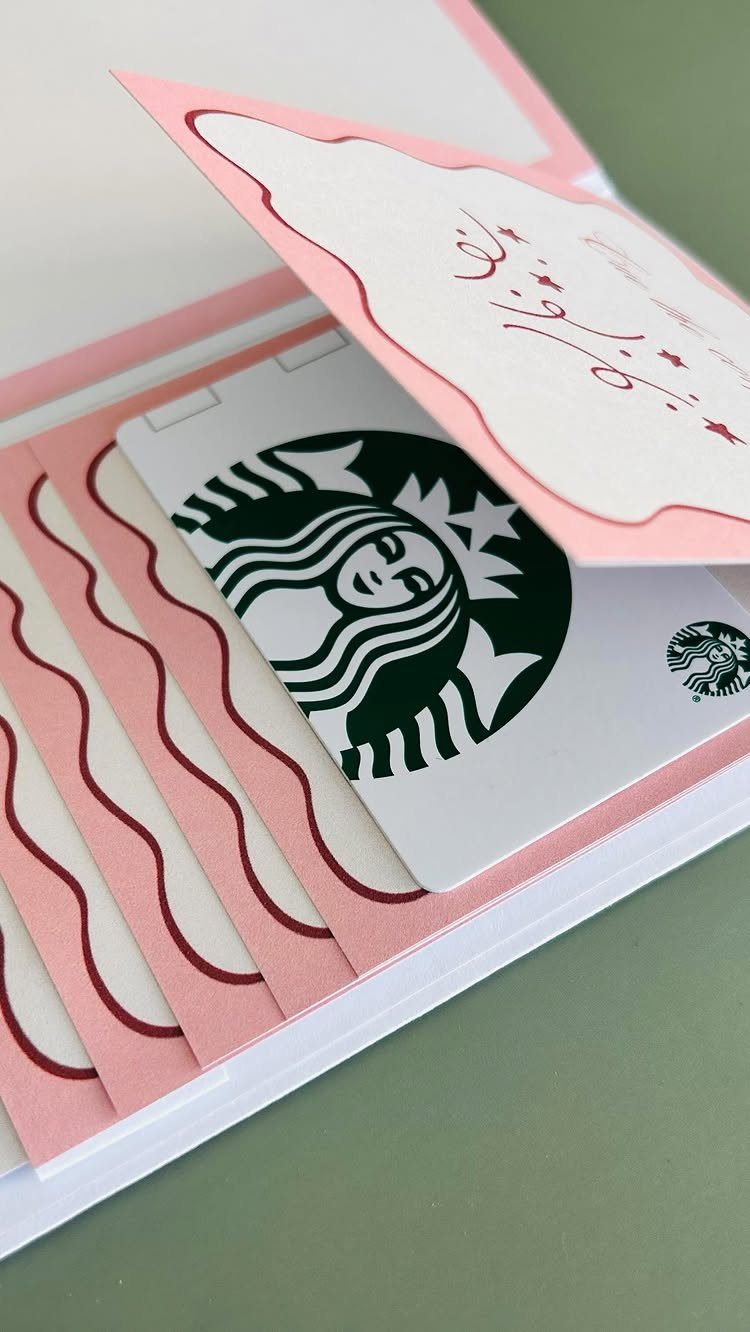 Starbucks gift card in a pink decorative holder with Arabic calligraphy card