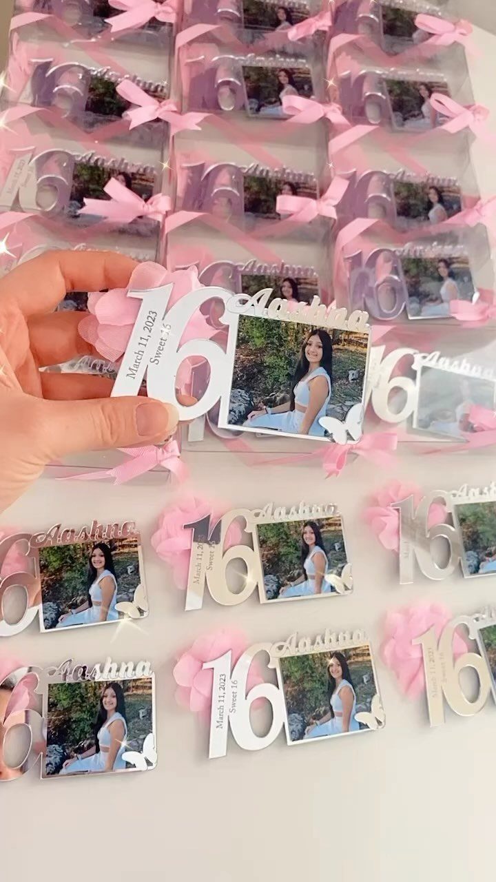 Personalized white acrylic sweet 16 party favors with photos and pink ribbons.