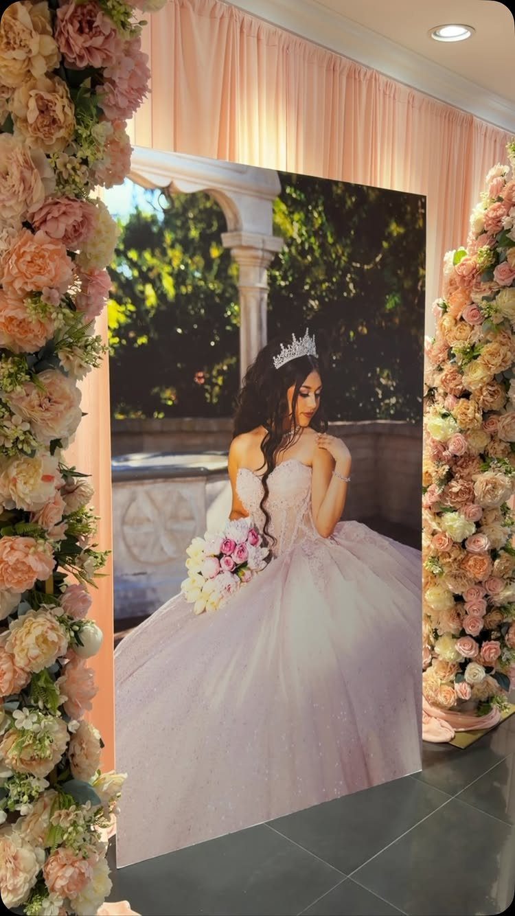 Large printed banner of a girl in a pink gown surrounded by floral pillars.