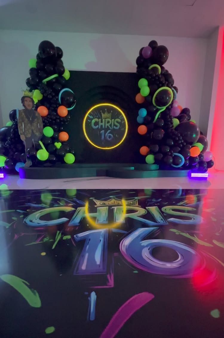Neon party setup with black and colorful balloons and a glowing Chris 16 sign.