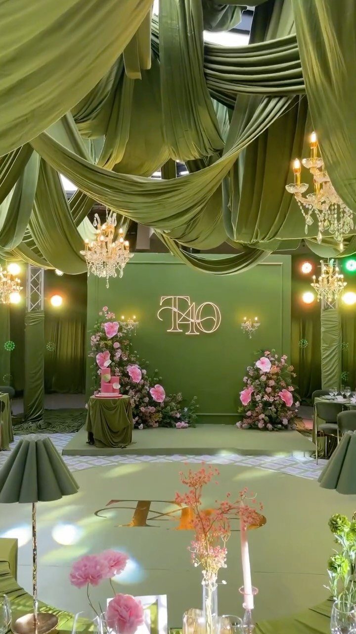 Olive green party decor with draped fabric, crystal chandeliers, and gold 40 sign.