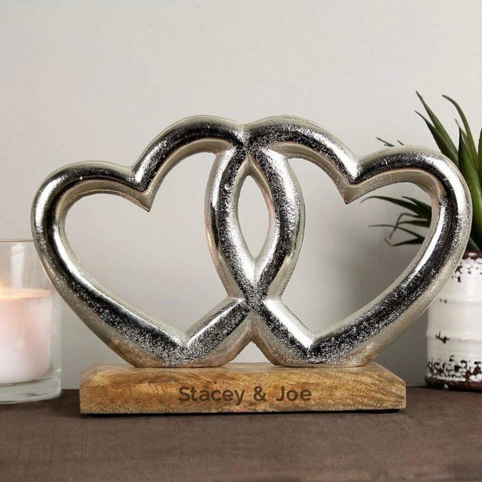 Interlocking silver hearts on a wooden base engraved with Stacey and Joe
