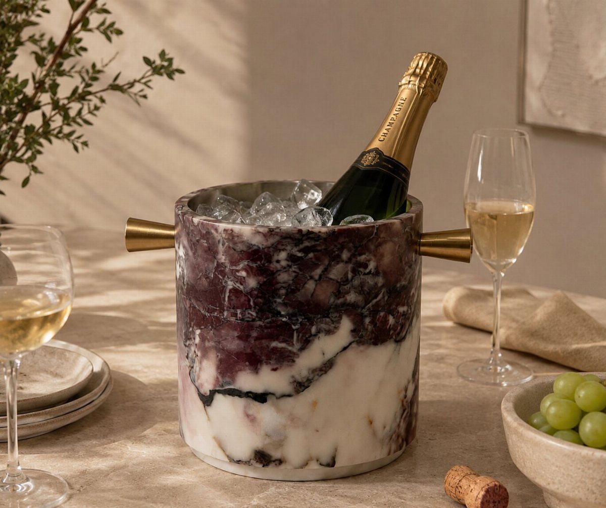Marbled stone wine chiller holding a champagne bottle with ice and wine glasses.