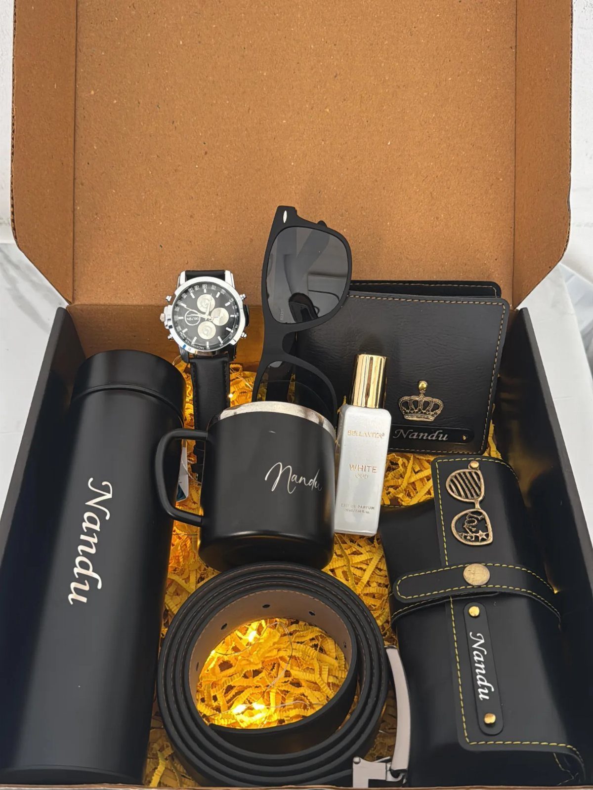 Personalized men's gift set with watch, wallet, and accessories in a black box.
