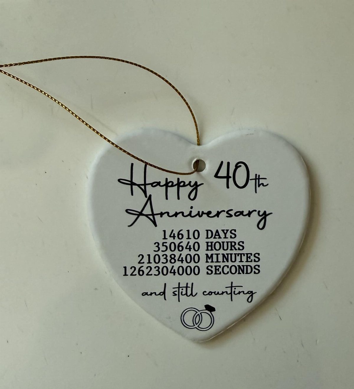 White heart-shaped ceramic anniversary ornament with 40th anniversary text and interlocking rings.