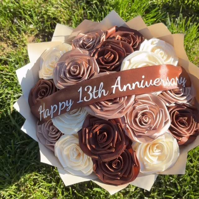 Satin ribbon rose bouquet with a Happy 13th Anniversary ribbon on green grass